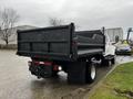 A 2005 GMC C5 Duramax dump truck viewed from the rear with a black bed and visible taillights