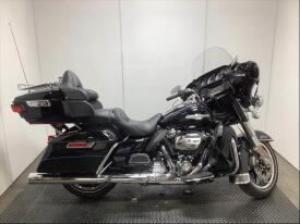 A 2018 Harley-Davidson FLHTK Shrine motorcycle in black with chrome accents featuring a large windshield saddlebags and a comfortable seat