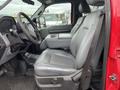 A gray leather seat in a 2011 Ford F-250 SD with a central armrest and control panel on the door side