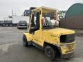 A yellow Hyster 120 forklift with a propane tank on top and large front tires parked on a paved surface