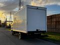 A 2017 Isuzu NPR box truck with a plain white cargo area facing away from the viewer