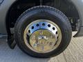 A close-up of a 2017 Ford Transit wheel featuring a shiny silver hubcap and a black tire with visible tread patterns