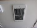 A white vent cover on the wall of a 2004 Royal 18 Foot Office Trailer with metal slats and a rectangular shape