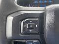 Close-up of the steering wheel controls of a 2017 Ford F-550 featuring navigation and selection buttons