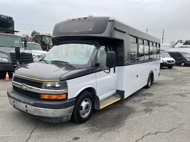 A 2017 Chevrolet Express bus with a black front and white body displaying large windows and a step up at the entrance