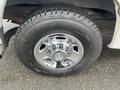 The image shows a close-up of a shiny chrome wheel and tire from a 2014 Chevrolet Express with a Firestone brand tire tread visible