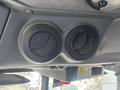 Two circular black dials on a textured gray panel inside a vehicle, likely for adjusting temperature or airflow