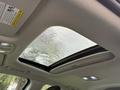 Sunroof of a 2021 Kia Forte with raindrops on the glass showing a blurred view of palm leaves outside