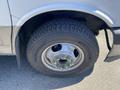 Close-up of a 2020 Chevrolet Express tire showing a steel wheel with green lug nut covers and tread pattern on the tire