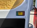 A control panel with a green "lock" button, a yellow "unlock" button, and a red indicator light, mounted on the side of a 2016 Ford Transit van