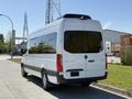 A 2023 Mercedes-Benz Sprinter van in white with a high roof and large windows parked on a street
