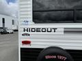 A 2022 Keystone Hideout RDWE 20RDWE travel trailer featuring a black and white exterior with the word Hideout prominently displayed on the side