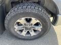 Close-up of a 2014 Ford F-150 wheel featuring a silver alloy rim and a rugged tire with visible tread patterns
