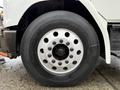 Close-up of the front wheel of a 2003 Freightliner FL70 showing the tire and metallic rim with multiple lug nut holes