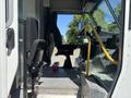 Interior of a 2019 Freightliner MT45 showing the driver's seat and controls with a metal floor and a handrail for support