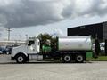 A 1996 Kenworth T800 truck with a green tank mounted on the back and notable exhaust pipes on the side