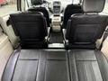Interior view of a 2017 Dodge Grand Caravan showing two rows of black leather seats and a center console in the front