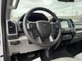 Interior view of a 2022 Ford F600 showcasing the steering wheel and control panel with various buttons and a touchscreen display
