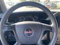 Interior view of a 2012 GMC Savana steering wheel with the GMC logo and dashboard gauges visible