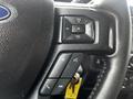A close-up of the steering wheel controls in a 2017 Ford F-150 featuring buttons for volume, media, and phone communication