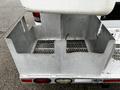 A metal storage compartment mounted on the back of a vehicle with a grated bottom and open sides designed to hold equipment or tools