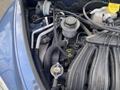 A 2007 Chrysler PT Cruiser engine compartment showing various components including hoses a cap and a reservoir