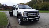 A 2019 Ford F-550 truck with a flatbed and dual rear wheels parked on a paved surface