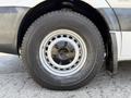 Close-up of a tire on a 2016 Mercedes-Benz Sprinter showing a silver rim with a star emblem and a durable black tire tread