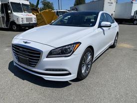 A white 2017 Genesis G80 luxury sedan with a sleek design, featuring a prominent grille, stylish headlights, and chrome accents on the wheels