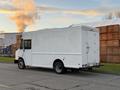 A white 2017 Freightliner M Line box truck with a rear door and smoke emitting from the exhaust pipe