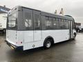 A 2017 Chevrolet Express bus with a gray and white exterior featuring large windows on the side and a rounded rear design