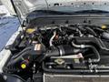 Close-up view of the engine compartment of a 2011 Ford F-450 SD showing various components including hoses wires and a battery