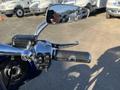 Close-up of a 2017 Harley-Davidson FLHXS motorcycle's handlebars with controls and a chrome grip reflecting sunlight