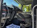 The interior of a 2005 Volvo VND 122 featuring a driver's seat steering wheel dashboard and controls