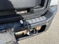 A 2015 Ford F-450 SD's front grille showing a close-up of wiring connections near the bumper and a worn textured surface