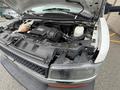 A 2017 Chevrolet Express with its hood raised showing the engine compartment and components including hoses and a reservoir