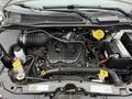 Engine compartment of a 2017 Dodge Grand Caravan featuring a black plastic engine cover various hoses belts and fluid reservoirs