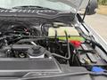 The engine compartment of a 2022 Ford F600 showing the engine components battery coolant reservoir and various hoses and wires