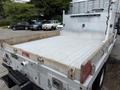 A 2015 Ford F-350 SD truck with a flatbed that has wooden side rails and a metal rear gate