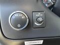 The dashboard control panel of a 2014 Chevrolet Express featuring dials for headlight settings and dome light control