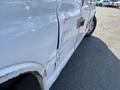 A 2014 Chevrolet Express van with a dented side panel and visible rust on the lower section