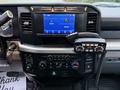 The interior dashboard of a 2023 Ford F-250 featuring a touchscreen display radio controls and a mounted CB radio