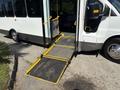 A 2017 Chevrolet Express with a wheelchair ramp extended from the side door