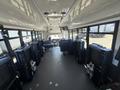 Interior view of a 2020 Chevrolet Express showing rows of blue fabric seats and storage compartments along the sides
