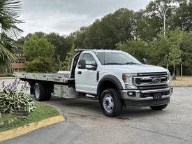 A 2022 Ford F600 truck with a flatbed design parked in an outdoor setting showcasing its rugged build and features