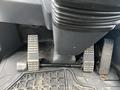 A close-up view of the foot pedals inside a 2016 Hyundai HL940 featuring two pedals with textured surfaces and a rubber floor mat beneath them