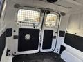 Interior view of a 2015 Chevrolet City Express cargo van showing the back doors with a metal grid and black paneling on the walls