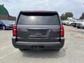 A black 2016 Chevrolet Tahoe viewed from the rear showcasing its taillights and rear hatch design