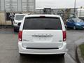A white 2017 Dodge Grand Caravan viewed from the rear without a license plate