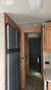 A 2007 Winnebago Adventure featuring a refrigerator and wooden cabinetry with a hallway leading to another room visible in the background